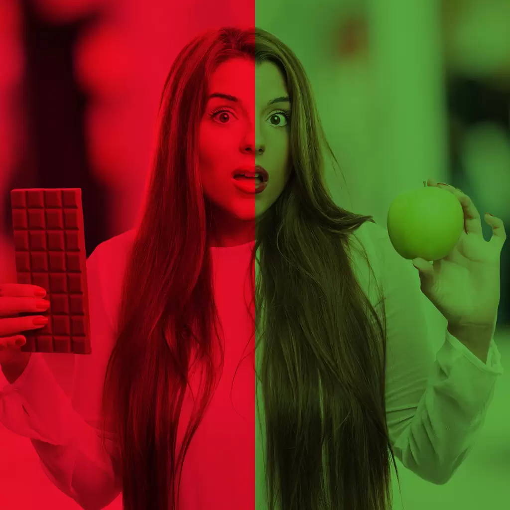 unhealthy v healthy food - girl holding a chocolate bar and an apple