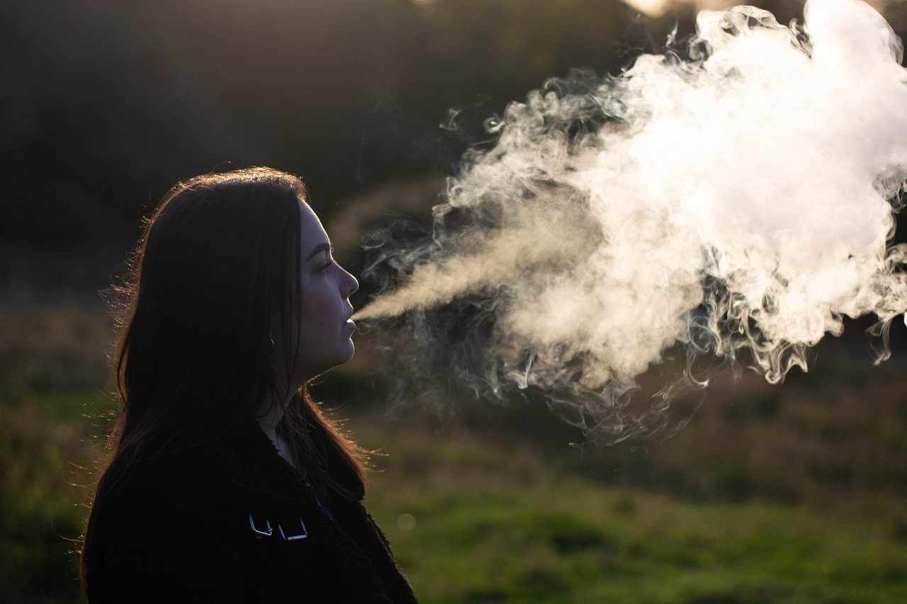 woman blowing big clouds from vaping