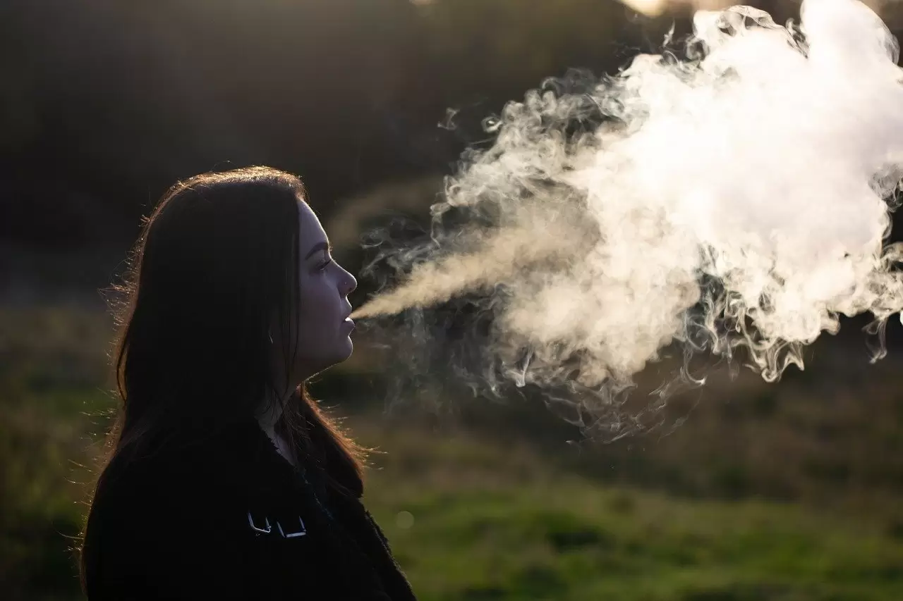 woman blowing big clouds from vaping