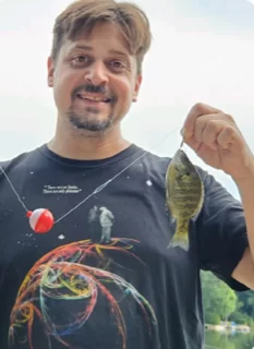 michael redfern holding a caught fish up in the air