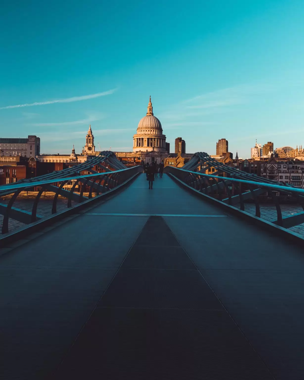 Millennium Bridge St Paul's Cathedral on modern London city skyline with blue sky